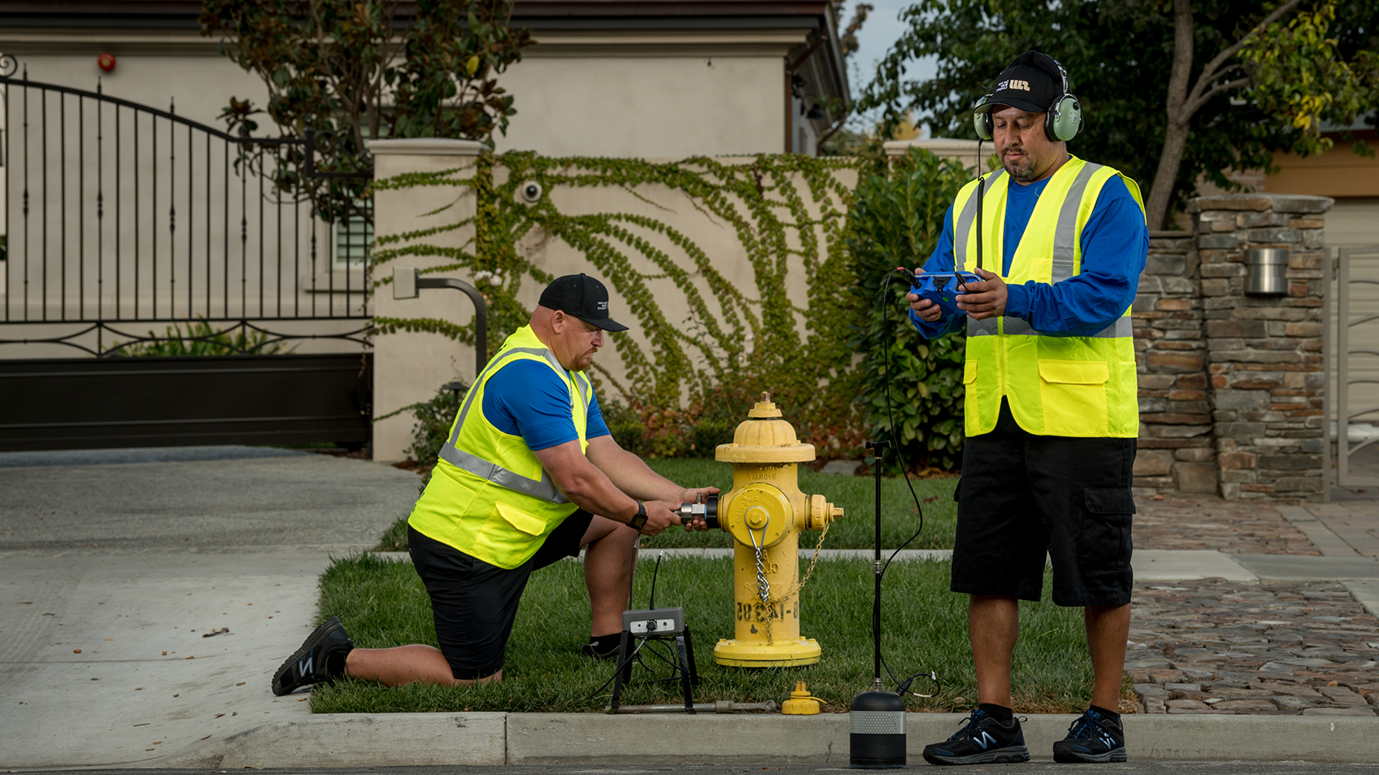 Two male San Jose Water employees checking a residential fire hydrant